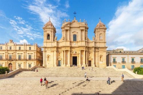 a large building with stairs in front of it at "Cuore Barocco" Hospitality in Noto in Noto