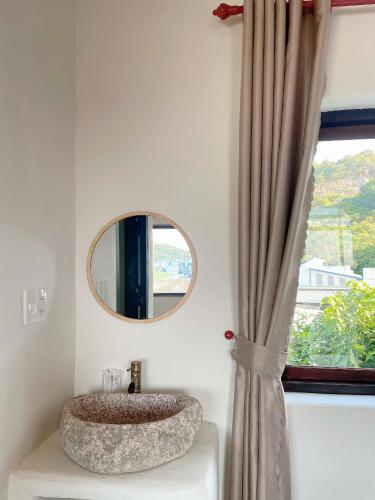 a bathroom with a stone sink and a mirror at Mộc House in Ninh Hải