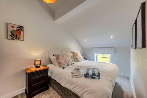 a bedroom with a white bed with a night stand at Greenwood House in Whitegate