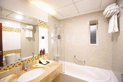 a bathroom with a sink and a bath tub at Tulip Hotel Apartments in Dubai