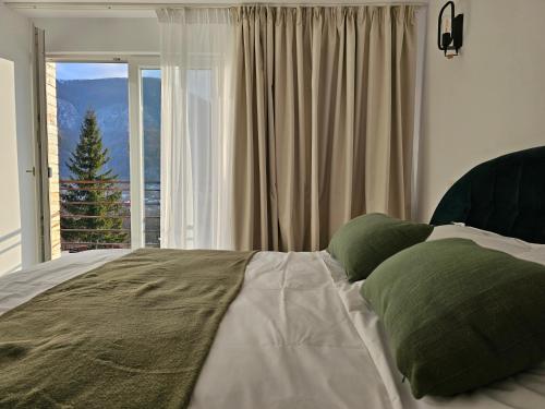a bedroom with a bed with a large window at FurtuNest in Roşcoiu
