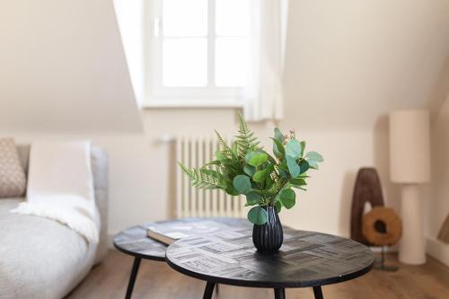 a vase with flowers on a table in a living room at Boutique Charme Apartments Küferstr 10-12 in Baden-Baden