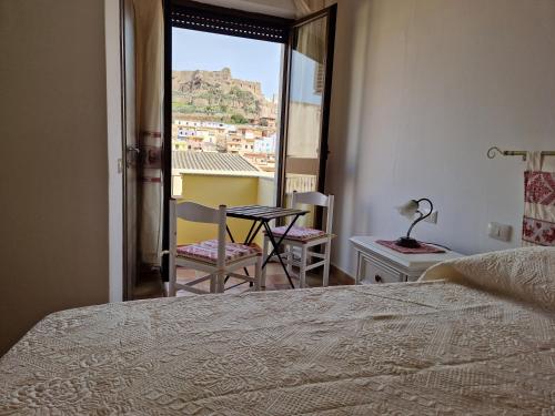 a bedroom with a bed and a table and chairs at B&B Nonna Sini in Castelsardo