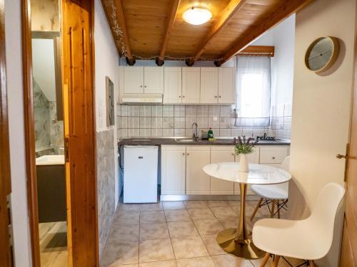 a kitchen with a table and a white refrigerator at Doukas Apartments & Studios in Skala Marion
