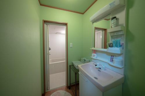 a bathroom with a sink and a mirror at Guesthouse SHELL in Naoshima