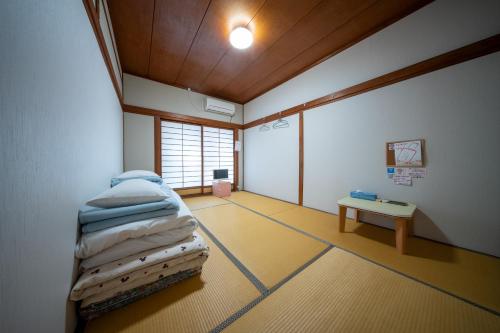 a room with a bed and a table in it at Guesthouse SHELL in Naoshima