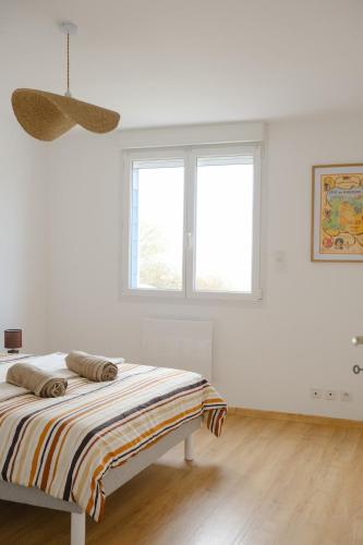 a white bedroom with a bed and two windows at Les Embruns, 4 personnes in Criel-sur-Mer