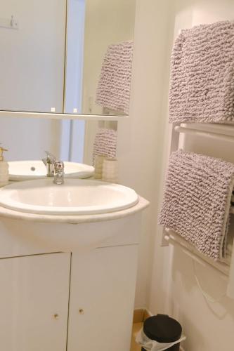 a bathroom with a sink and a mirror and towels at Les Embruns, 4 personnes in Criel-sur-Mer