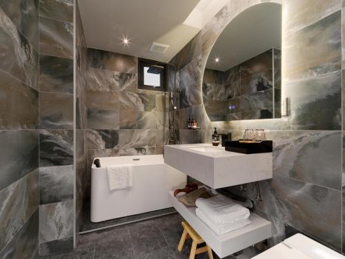 a bathroom with a white sink and a mirror at The Zen in Jiufen