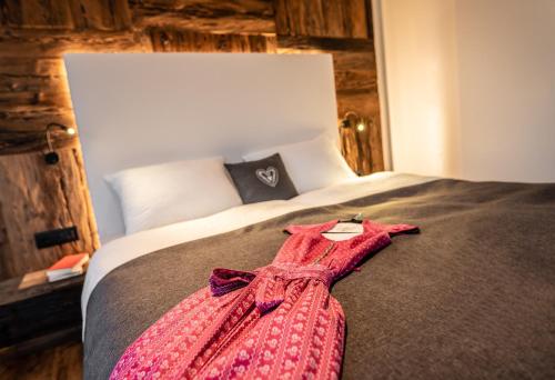 a pink dress is laying on a bed at Bellevue Bruneck - Suites & Lofts in Brunico