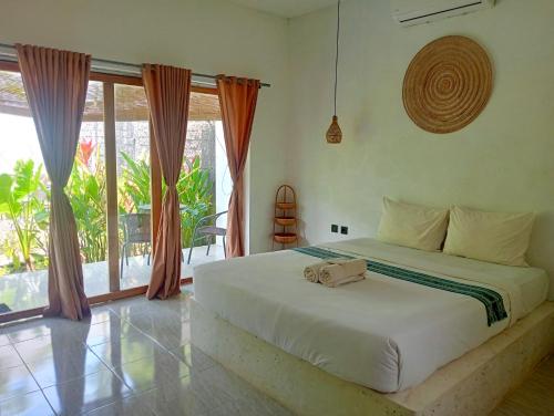 a bedroom with a bed and a large window at Palmhouse Boutique Hotel in Kuta Lombok