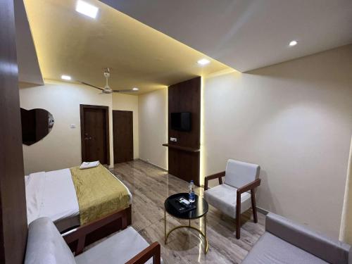 a hotel room with a bed and a chair at Hotel SHREE PALACE in Ratlām