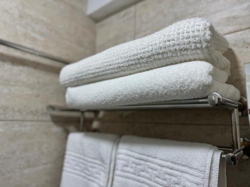 a stack of towels on a towel rack in a bathroom at Senin Vama Veche in Vama Veche