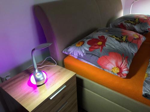 a bedroom with a bed and a night stand with a lamp at Bibina in Levoča