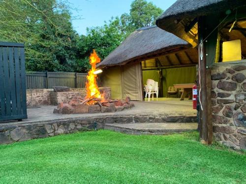 a fire pit in a yard with a tent at Lapa Phanzi Game Lodge in Modimolle