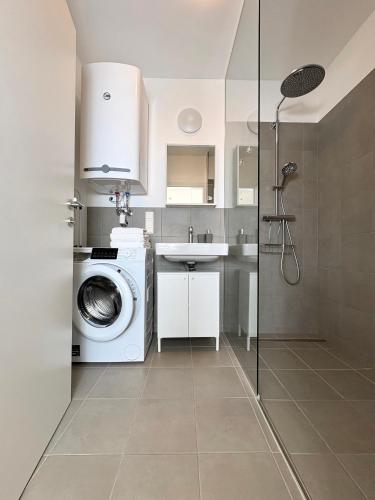 a bathroom with a washing machine and a sink at Seelavie in Podersdorf am See