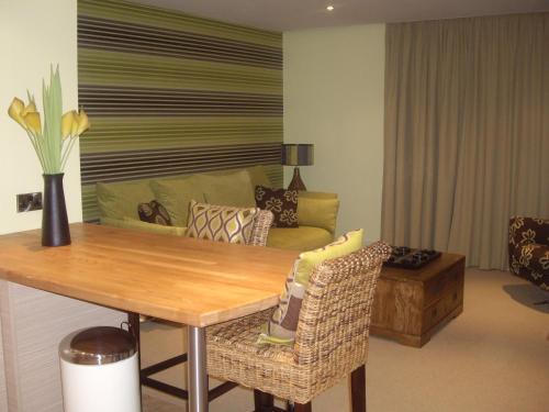 a living room with a table and a couch at Portland Apartments in Cheltenham