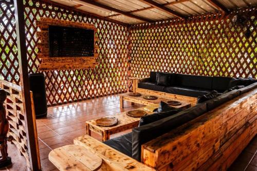 a room with a couch and tables in a wooden room at Kê Vitamina - Solar dos Ananases in Santo Amaro