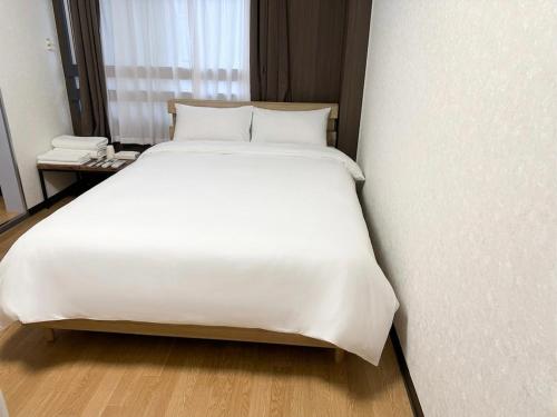 a large white bed in a hotel room at 亀井町Stay401 in Takamatsu