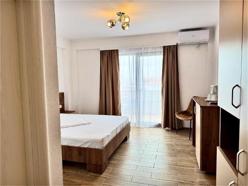 a hotel room with a bed and a window at Senin Vama Veche in Vama Veche