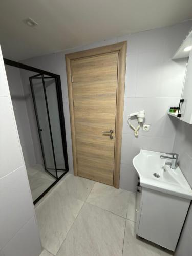 a bathroom with a wooden door and a sink at Liora Old City in Istanbul