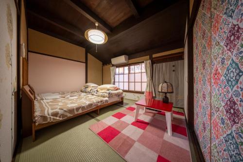 a bedroom with a bed and a table in a room at Oyajino Umi in Naoshima