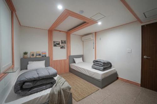 a bedroom with two beds with towels on them at Midpoint Guesthouse in Busan