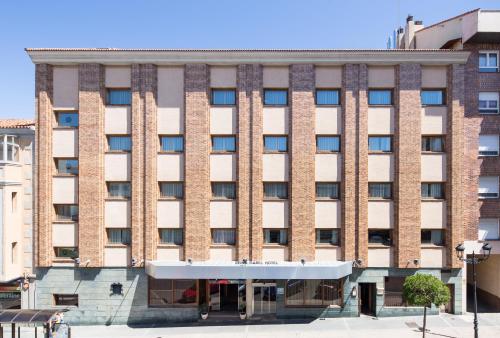 a large brick building on a city street at Dorma Reina Isabel in Ávila
