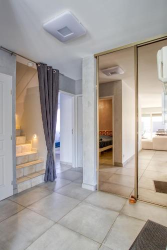 a living room with glass walls and a staircase at Superbe Villa, 4 chambres, parking, garage et piscine in Genas