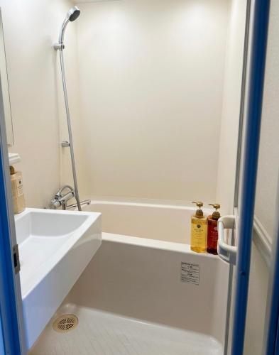 a bathroom with a white tub and a sink at 亀井町Stay501 in Takamatsu