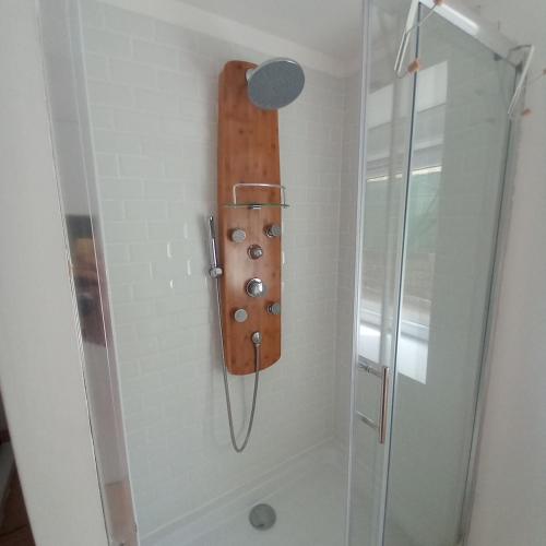 a shower with a wooden board on the wall at Cozy countryside apartment in Moriville