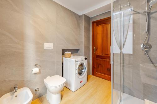 a bathroom with a washing machine and a toilet at The Nest Between Lake Como e Bellagio in Castelmarte