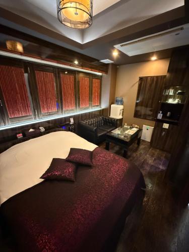 a bedroom with a bed and a living room at H-Seven Nishikawaguchi (Adult Only) in Kawaguchi
