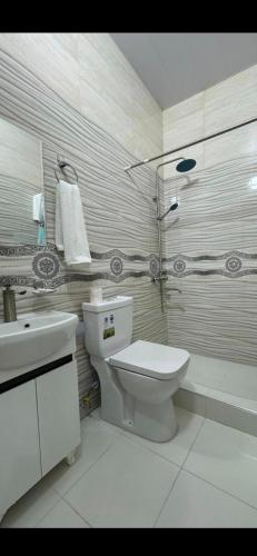 a white bathroom with a toilet and a sink at HOTELVAZIRA in Samarkand
