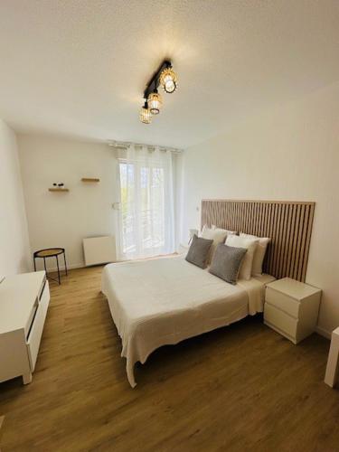 a bedroom with a large bed and a window at Sphinx Résidences - Tempologis Mémorial in Caen