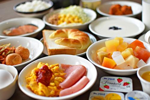 a table topped with bowls of different types of food at Hotel Tulip Ishigakijima in Ishigaki Island