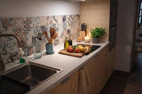 a kitchen counter with a sink and a cutting board with fruit at El Apartamento de Hervás in Hervás