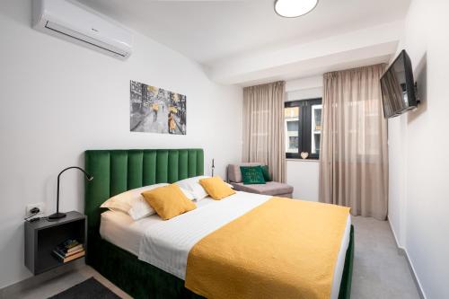 a bedroom with a large bed with a green headboard at Apartment Skyline two-bedroom apartment with balcony in Cavtat