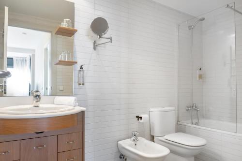 a white bathroom with a toilet and a sink at Pierre & Vacances La Merceria in El Tarter