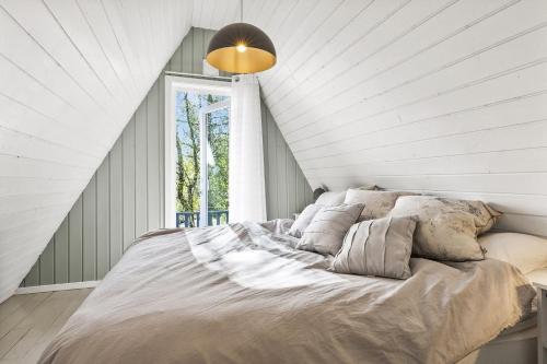 a bedroom with a large bed with a window at Trekanthytte in Moss