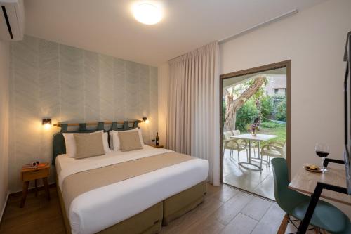 a bedroom with a large bed and a patio at כפר נופש קלי"ה ים המלח in Kalia