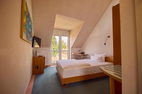 ein kleines Zimmer mit einem Bett und einem Fenster in der Unterkunft Hotel Watthalden in Ettlingen