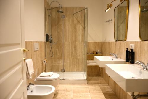 een badkamer met twee wastafels, een toilet en een douche bij The Talent Hotel in Rome