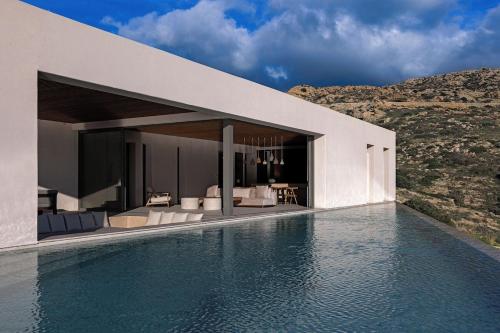 a house with a swimming pool next to a mountain at Crimson View Villa by Hide Out in Ios Chora