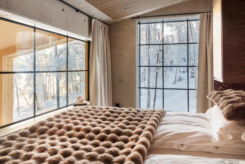 a bedroom with a large bed in front of windows at Taikavilla in Kuusamo