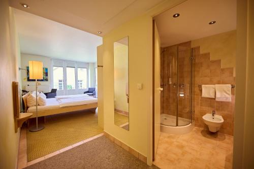ein Badezimmer mit Dusche und ein Schlafzimmer mit Bett in der Unterkunft Hotel Watthalden in Ettlingen