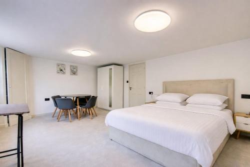 a bedroom with a large white bed and a table at Stylish 2BR Apartment in Leicester Square in London