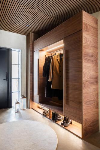 a dressing room with a large wooden cabinet with shoes in it at Taikavilla in Kuusamo