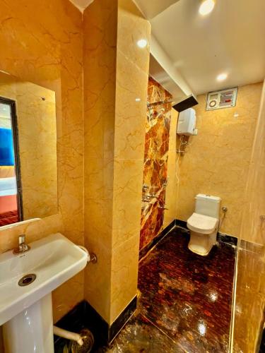 a bathroom with a sink and a toilet at Bengal Guest House in Howrah