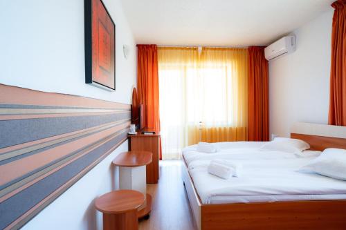 a hotel room with two beds and a window at Motel Delorean in Săcele